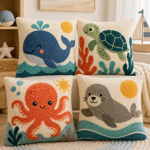 May include: Four square throw pillows featuring textured, tufted designs of a blue whale, a green sea turtle, an orange octopus, and a gray seal. Each pillow has a cream-colored background with colorful marine life and yellow suns.