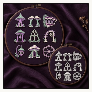 May include: Two circular wooden embroidery hoops containing dark purple fabric. The larger hoop features nine embroidered designs in shades of green, purple, and white, depicting mushroom-shaped structures, arches, and floral motifs. The smaller hoop displays the same nine designs in white thread.