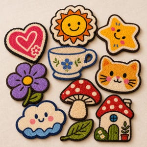 May include: A collection of colorful, embroidered patches in various shapes, including a heart, sun, star, flower, teacup, cat face, mushroom, cloud, leaf, and house. Each patch features a detailed design with a textured, raised appearance and a black border.