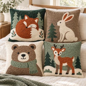 May include: Four square throw pillows featuring textured punch needle designs of woodland animals. One shows a sleeping fox in a dark green forest, one a white rabbit, one a brown bear wearing a green scarf, and one a deer in a light green forest.