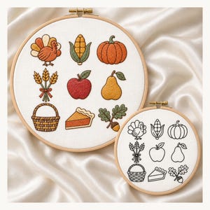 May include: Two circular wooden embroidery hoops containing white fabric. The larger hoop features colorful embroidered autumn icons: a turkey, corn, pumpkin, wheat, apple, pear, basket, pie slice, and acorn. The smaller hoop shows matching black outlines.