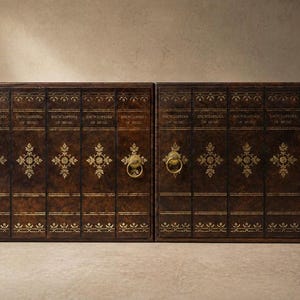 May include: Two matching dark brown cabinets with gold accents and ring pulls. Each cabinet is designed to look like a set of books, with the words "Encyclopedia of Music" printed on the spines. The cabinets have decorative gold floral patterns.