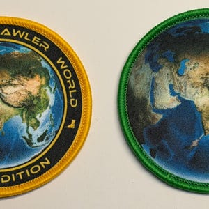 Pode incluir: Dois emblemas bordados circulares com uma vista de satélite detalhada da Terra. O emblema esquerdo tem uma borda amarela e texto preto lendo DUNGEON CRAWLER WORLD EARTH EDITION. O emblema direito apresenta uma borda verde sólida.
