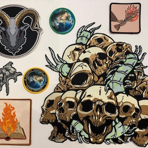 May include: A collection of embroidered patches featuring a large pile of skulls with centipedes, a goat head, a spider, a book with flames, a hand holding a torch, and two circular patches depicting the Earth with text reading Dungeon Crawler World.