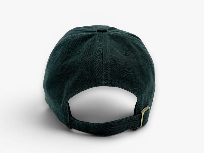 May include: Dark green baseball cap with a curved brim and adjustable strap. The cap is made of a soft fabric and features a metal buckle closure. The back of the cap is visible against a white background.