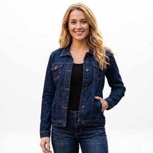 Könnte beinhalten: Dunkelblaue Jeansjacke mit Knopfverschlüssen, Brusttaschen und Seitentaschen. Die Jacke wird mit passender Jeans und einem schwarzen Oberteil kombiniert. Das Model lächelt.