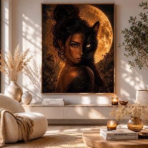 Könnte beinhalten: Ein gerahmtes Kunstwerk zeigt eine Frau mit einer schwarzen Katze vor einem Vollmond. Das Kunstwerk wird in einem hellen Raum mit neutralen Tönen, einem modernen Stuhl und dekorativen Pflanzen ausgestellt. Die Szene wirkt warm und einladend.