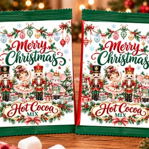 May include: Two rectangular packets of hot cocoa mix featuring a Merry Christmas design with illustrations of nutcrackers, a ballerina, and a mouse. The packaging includes green borders, red accents, and a festive scene with ornaments and pine trees.