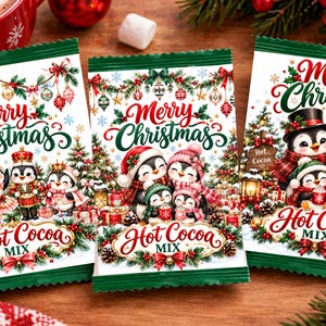 May include: Three rectangular packets of hot cocoa mix featuring festive illustrations of penguins, Christmas trees, and ornaments. Each packet displays the text Merry Christmas and Hot Cocoa Mix in red and green decorative script fonts.