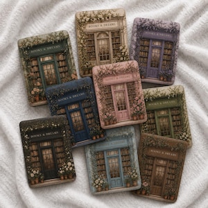 Op de afbeelding: Een verzameling rechthoekige onderzetters met een vintage boekwinkelontwerp. Elke onderzetter heeft een ander kleurenschema, waaronder blauw, roze en groen, met de tekst "BOOKS & DREAMS" boven de deur.