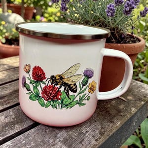 May include: A set of three ceramic mugs with a speckled, matte finish. Each mug features a different color: light blue, cream, and gray. The mugs have a simple, modern design and a comfortable handle.