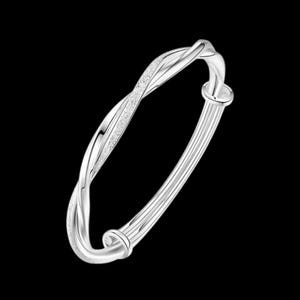 Puede incluir: Una pulsera de plata con un diseño retorcido. Un lado de la pulsera tiene una apariencia texturizada y brillante. El otro lado presenta una serie de líneas paralelas. La pulsera tiene un cierre de broche.