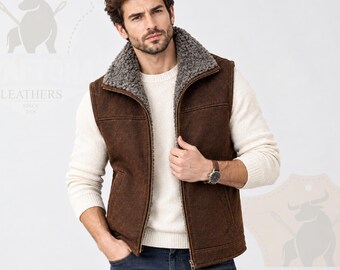 Peut inclure: Un gilet en cuir marron doté d'une doublure en fausse fourrure grise et d'un col montant. Le gilet possède une fermeture éclair frontale et deux poches latérales. Il est porté sur un pull en tricot crème et un jean bleu.