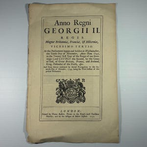 May include: A historical document titled "Anno Regni GEORGII II." printed in black ink on aged, cream-coloured paper. The text is in Latin and English, featuring a royal crest and the word "LONDON." The document is from 1750.