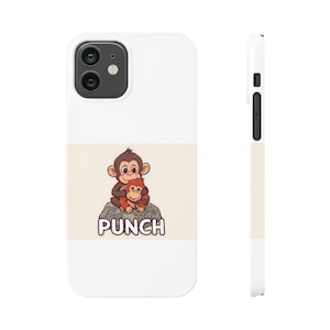 Könnte beinhalten: Weißes Handycase mit einer Cartoon-Illustration von zwei Affen auf einem Felsen, darunter das Wort "PUNCH". Die Affen sind braun und orange, und der Felsen ist grau. Das Case hat einen weißen Hintergrund mit einem beigen Streifen.