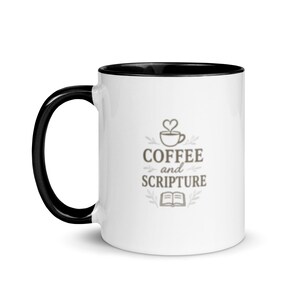 May include: White ceramic coffee mug with a black handle and interior. The mug features the words "COFFEE and SCRIPTURE" in a grey, stylised font, along with a coffee cup and open book graphic.
