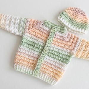 May include: A set of three ceramic mugs with a speckled, matte finish. Each mug features a different color: light blue, cream, and gray. The mugs have a simple, modern design and a comfortable handle.