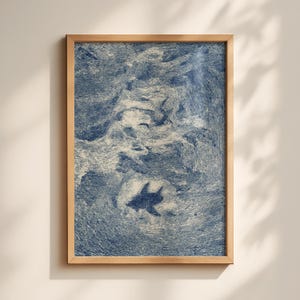 Puede incluir: Una impresión artística enmarcada que presenta una ilustración estilizada de un tiburón nadando en agua azul arremolinada. La obra de arte tiene una estética vintage, con una apariencia detallada y texturizada. El marco es de madera clara.