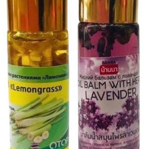 May include: Two glass bottles of oil balm with gold-coloured caps. One is labelled "Lemongrass" with a green and yellow label. The other is labelled "Oil Balm with Herb Lavender" with a purple label.
