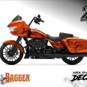 Può includere: Una motocicletta arancione brillante con componenti meccanici e ruote nere. La carrozzeria è decorata con intricati motivi a volute neri. Il testo HRX Project 2 e Bagger HRX Project DECAL appaiono nell'immagine.