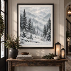 May include: A framed wall art print depicting a snowy mountain landscape with evergreen trees covered in frost, set against a misty, overcast sky. The artwork is displayed in a dark wooden frame, showcasing a winter scene with white snow.