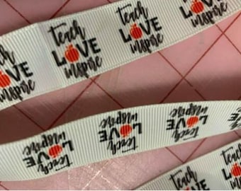 May include: White ribbon with the text "Teach Love Inspire" repeated with a small orange pumpkin graphic.