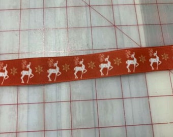 May include: Orange ribbon with a white repeating pattern of reindeer and stars.