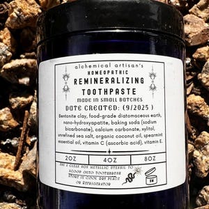 May include: A dark blue jar of remineralizing toothpaste with a white label. The label includes the text "REMINERALIZING TOOTHPASTE" and ingredient information. The jar is available in 2oz, 4oz, and 8oz sizes.