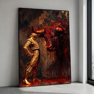 May include: A large framed artwork depicts a golden matador facing a massive, red bull. The bull's head is detailed with dripping blood, set against a textured, dark background. The matador is in a gold suit.