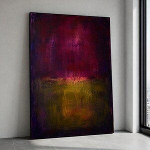 Puede incluir: Gran pintura abstracta enmarcada. La obra presenta un degradado de colores, con borgoña oscuro y morado en la parte superior, pasando a amarillo y marrón en la parte inferior. La pintura está apoyada contra una pared blanca.