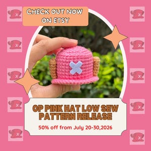 May include: A small, pink, crocheted hat with two brown, textured, antler-like protrusions on the sides and a light blue, felt-like cross emblem on the front. The text on the image reads: CHECK OUT NOW ON ETSY, OP PINK HAT LOW SEW PATTERN RELEASE, 50% off from July 20-30, 2026.