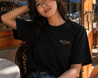 BE TAIL x KANAEBASE T-shirt i bomull med guldfärgad logotyp, japansk minimalistisk stil