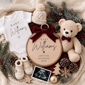 May include: A baby announcement set featuring a white onesie, a wooden sign with "Baby Williams", and a sonogram image. The sign is adorned with a burgundy bow. Additional items include a teddy bear, knitted booties, and a winter hat. The announcement reads "Arriving December 202X".