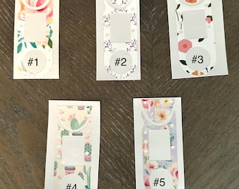 May include: Five floral-themed stickers with a white background and a rectangular cutout. Each sticker features a different design, including watercolor flowers, a wreath, and cacti. Each sticker is labeled with a number from 1 to 5.
