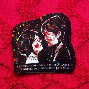 May include: A sticker with a dark background featuring a couple in a romantic embrace, with blood-like markings on their faces. The sticker has a holographic effect with colorful stars. Text at the bottom reads: "THE STORY OF A MAN, A WOMAN, AND THE CORPSES OF A THOUSAND EVIL MEN."