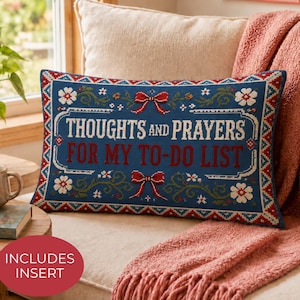 May include: A rectangular throw pillow with a dark blue background featuring the text THOUGHTS AND PRAYERS FOR MY TO-DO LIST in white and red. The design includes red bows, green vines, and white flowers with a geometric border pattern.
