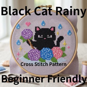 Puede incluir: Un patrón de punto de cruz en un bastidor de madera, con un gato negro bajo la lluvia, sosteniendo flores. El texto dice "Black Cat Rainy", "Cross Stitch Pattern" y "Beginner Friendly". Los colores son negro, morado, rosa, azul y amarillo.