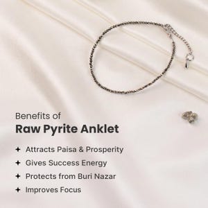 May include: A raw pyrite anklet featuring small, dark grey beads and a silver clasp, presented on a white satin backdrop. The image includes text detailing the anklet's benefits, such as attracting prosperity and enhancing focus.
