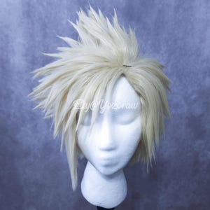 May include: A pale blonde synthetic wig with a highly spiked, layered, and voluminous hairstyle, displayed on a white mannequin head. The hair features sharp, angular tips and a textured, gravity-defying appearance with the text Etsy@Yozoraw.