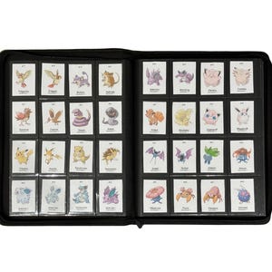 May include: A black, zippered binder filled with trading cards. The cards are in clear plastic sleeves and feature various colorful cartoon characters. The binder is open, displaying multiple rows of cards.