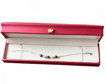 Pulsera de plata de ley con perlas alternadas en gris oscuro y plata, estilo minimalista.