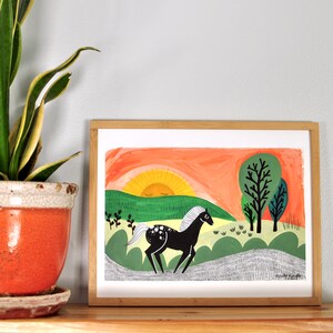 Puede incluir: Una ilustraci&oacute;n enmarcada de un caballo negro corriendo por un campo verde con un sol amarillo poni&eacute;ndose en el fondo. El sol tiene un ojo cerrado y el caballo tiene una crin y una cola blancas.