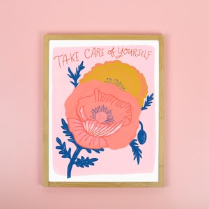 K&ouml;nnte beinhalten: Ein rosa-gelber Blumendruck mit dem Text "TAKE CARE OF YOURSELF" in einem wei&szlig;en Rahmen.