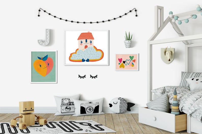 May include: A white wooden bed frame with a house-shaped headboard, a white and gray striped duvet cover, and a white and gray patterned throw pillow. There are several colorful framed prints on the wall behind the bed, including a peach, a house in a cloud, and a collection of hearts.