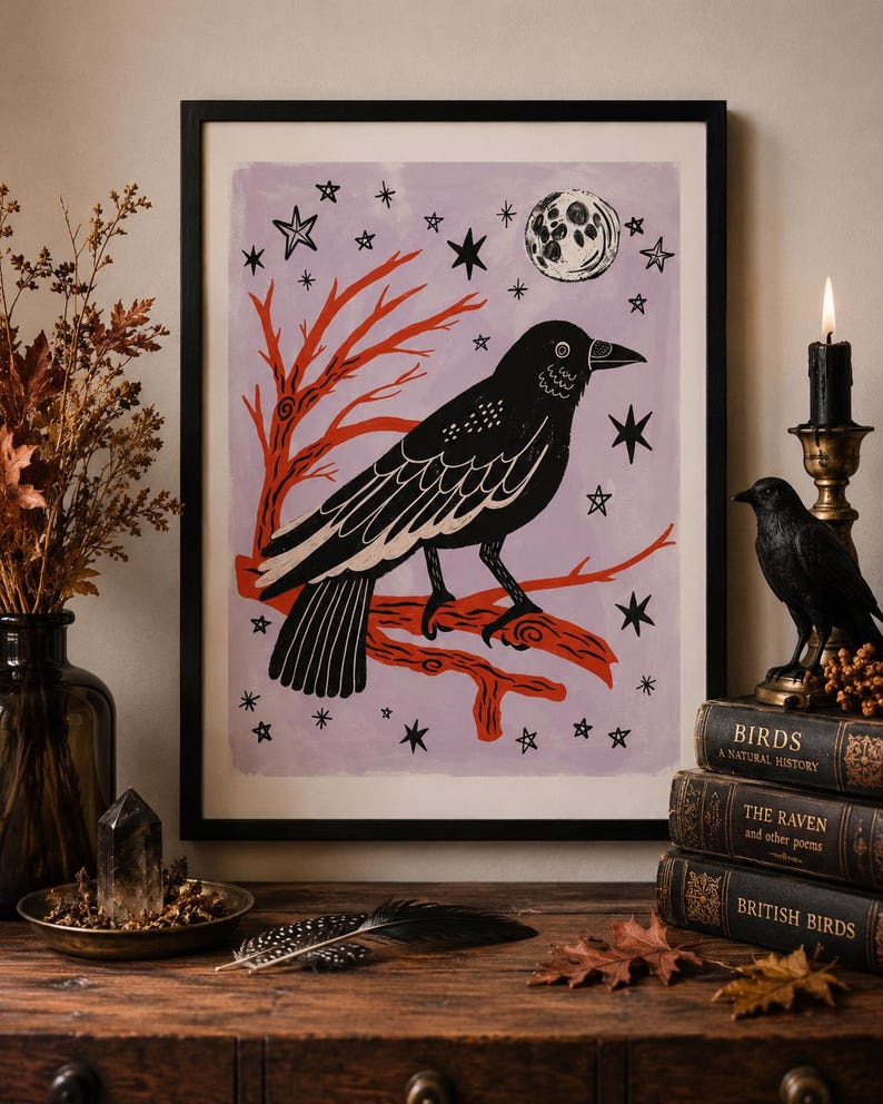 May include: A framed print featuring a black crow perched on a red branch against a light purple background. The artwork includes a white moon and several black stars. The crow is depicted in profile with detailed wing feathers and a sharp beak.