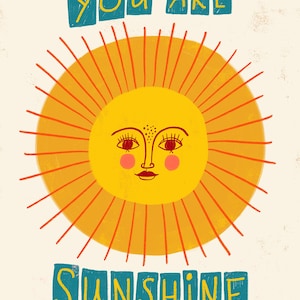 K&ouml;nnte beinhalten: Eine gelbe Sonne mit einem l&auml;chelnden Gesicht und orangefarbenen Strahlen. Der Text "YOU ARE SUNSHINE" ist in blauen Buchstaben geschrieben.