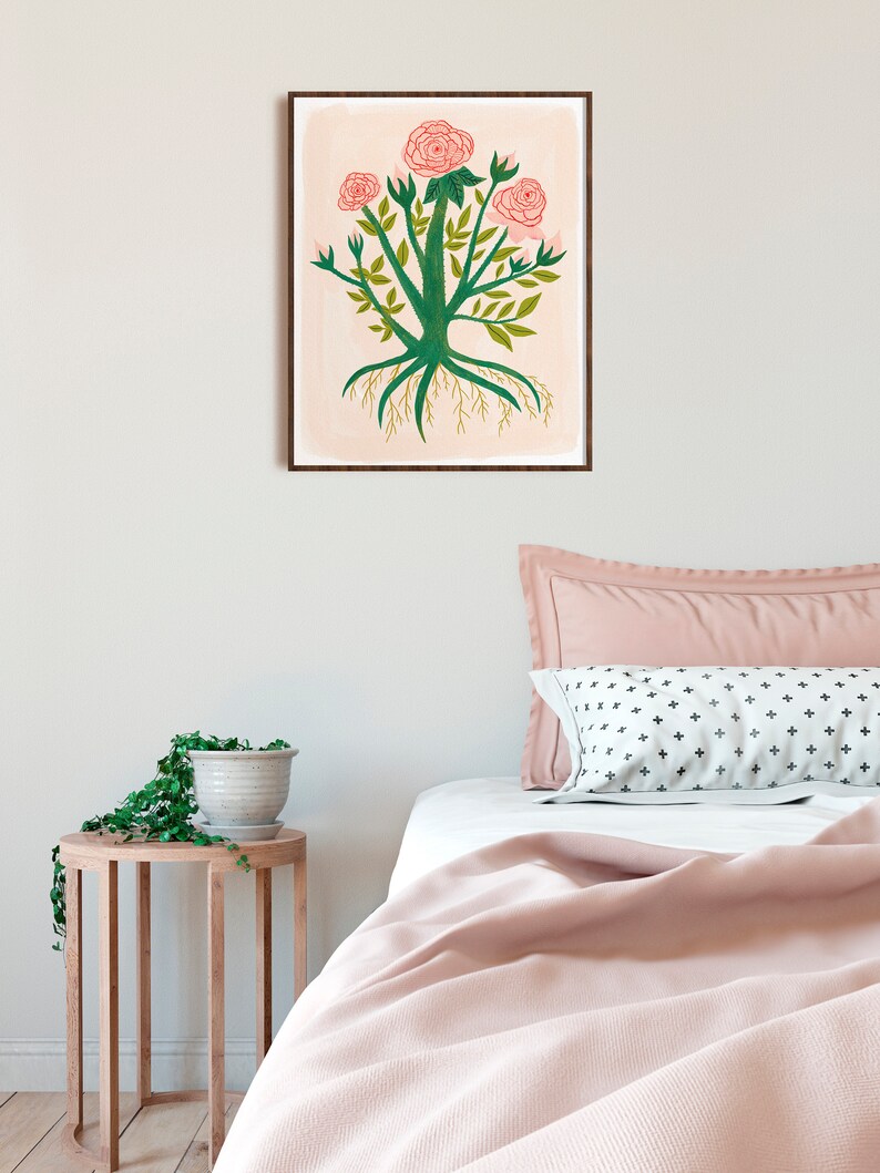 May include: A framed illustration of a pink rose bush with green leaves and roots. The background is a light pink watercolor wash.