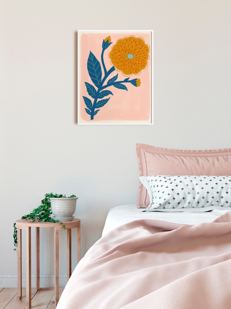 K&ouml;nnte beinhalten: Ein gerahmter Druck einer stilisierten orangefarbenen Blume mit blauen Bl&auml;ttern auf rosa Hintergrund.