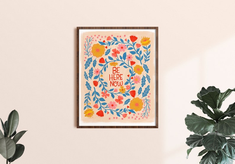 be here here now quote in red with blue, pink, yellow, coral and red folk inspired florals surround it.
