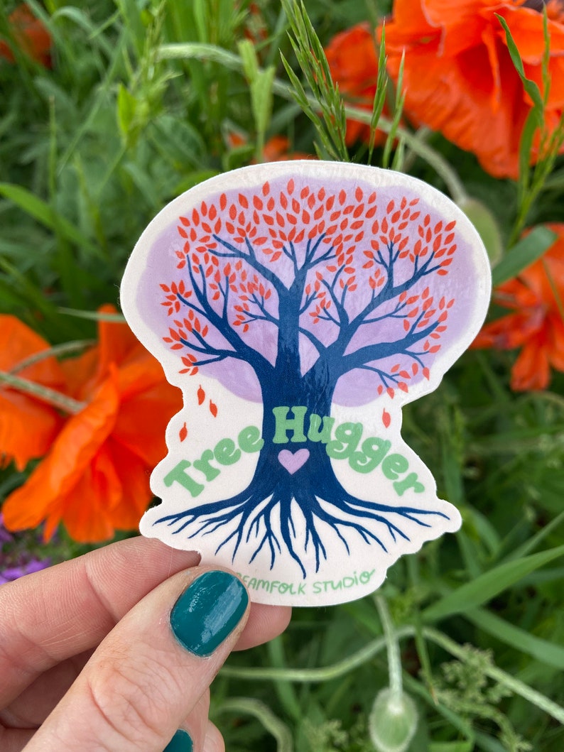 May include: A sticker featuring a stylized tree with red leaves and blue roots. The text "Tree Hugger" is written around the tree in green letters with a purple heart in the center. The sticker is on a white background and has a purple border.